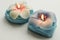 Two decorative burning candles in the shape of flowers