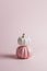 Two decorative glossy pumpkins standing vertically on top of each other on pink background