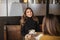 Two delighted women girlfriends drinking coffee and talking during meeting in cozy cafe