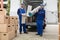 Two Delivery Men Holding Chairs And Carpet