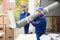 Two Delivery Men Holding Chairs And Carpet