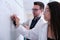 Two dentist researchers studying dental anatomy on a whiteboard.