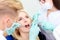 Two dentists treat their teeth to visitor in dental office