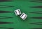 Two dice on a green gaming table.