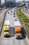 Two different big rig semi trucks with semi trailers running in front of another traffic on the road with overpass intersections