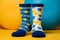 Two different mismatched socks on colorful yellow and light blue geometric shape background. Odd Socks Day, Lonely Sock