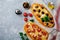 Two different oval Greek pizza with olives and tomato Margarita on gray concrete background. Selective focus. Top view. Copy space