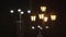 Two different street lanterns on black sky background. Stock footage. Old fashioned and modern street lamps with yellow