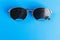 Two different type of glasses on blue background. Medical concept. Top view. Pinhole black eyeglasses help relaxing weary eyes Iso
