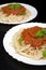 Two dish pasta with bolognese sauce on black