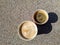 Two disposable portable paper cups of different sizes with coffee cast shadows on rough surface. Top view. Take-Away Coffee.