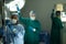 Two diverse female surgical techs adjusting light and iv bag in operating theatre during operation