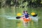 Two diverse little boys kayaking down a beautiful river