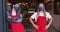 Two diverse male baristas wearing face masks and aprons standing in doorway of cafe