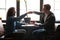 Two diverse men friends bumping fists above table at coffeehouse