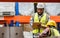 Two diverse professional male workers holding board, checking shipping stocks in storage, warehouse or factory for delivery,