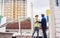 Two diversity male engineers team working, inspecting outdoor at construction site, wearing hard hats for safety, talking,