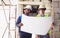 Two diversity male engineers team working, inspecting outdoor at construction site, wearing hard hats for safety, talking,