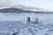 Two diving tanks and a buoy around a hole in ice in a frozen lake.