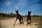 Two doberman dogs sitting in the field