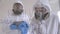 Two doctors in medical suits are investigating the Covid-19 virus in the lab.