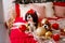Two dogs of Cavalier King Charles Spaniel are lying on the sofa with New Year decorations for the Christmas tree. Dog