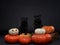 two dogs with pumpkins. black pugs, Halloween decor. Festive pet on a black background