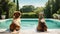 Two dogs sitting on the edge of the swimming pool