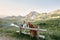 Two dogs, Tooller and a Jack Russell Terrier, lean on a fence in mountains