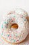 Two donuts with colorful sprinkles and glazes surface over colorful background