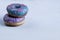 Two donuts with pink and blue glaze lie on top of each other.