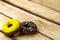 Two donuts yellow and chocolate on a wooden background. Free space for text. World donut da