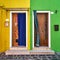 Two doors on the bright facade of the houses. Italy, Burano,