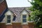 Two Dormers on Brick Homes with Wood Shingles