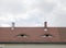 Two dormers with windows on repaired brown ceramic roof