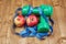 Two dumbbells, apples and a centimeter lie on a wooden surface