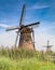 Two dutch windmills standing behind reed