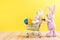 Two easter bunnies with shopping cart and easter eggs