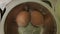 Two eggs boiling on the stove in a metal pot.