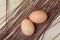 Two eggs resting on chopping board