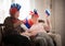 Two elderly enthusiastic women sitting in russian accessories and waving with russian flags