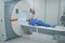 Two elderly women, doctor and patient are in MRI room