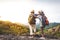 Two elderly women hiking backpacking And standing on a high mountain Happy retirement.