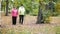 Two elderly women in jackets are doing Scandinavian walking in the park