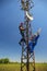 Two electricians install telecommunications antenna system