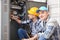 Two electricians near distribution board indoors