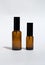 Two empty amber cosmetic sprays on a white background. Skin nature, beauty concept.