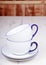 Two empty cups and saucers on a white wooden table