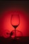 Two empty wine glass on red background. Luxury drink glasses in red lights