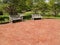 Two empty wood benches by a red patio